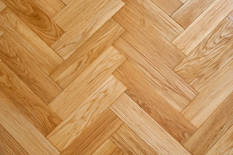 Herringbone oak parquet flooring filling the frame with natural wood grain pattern