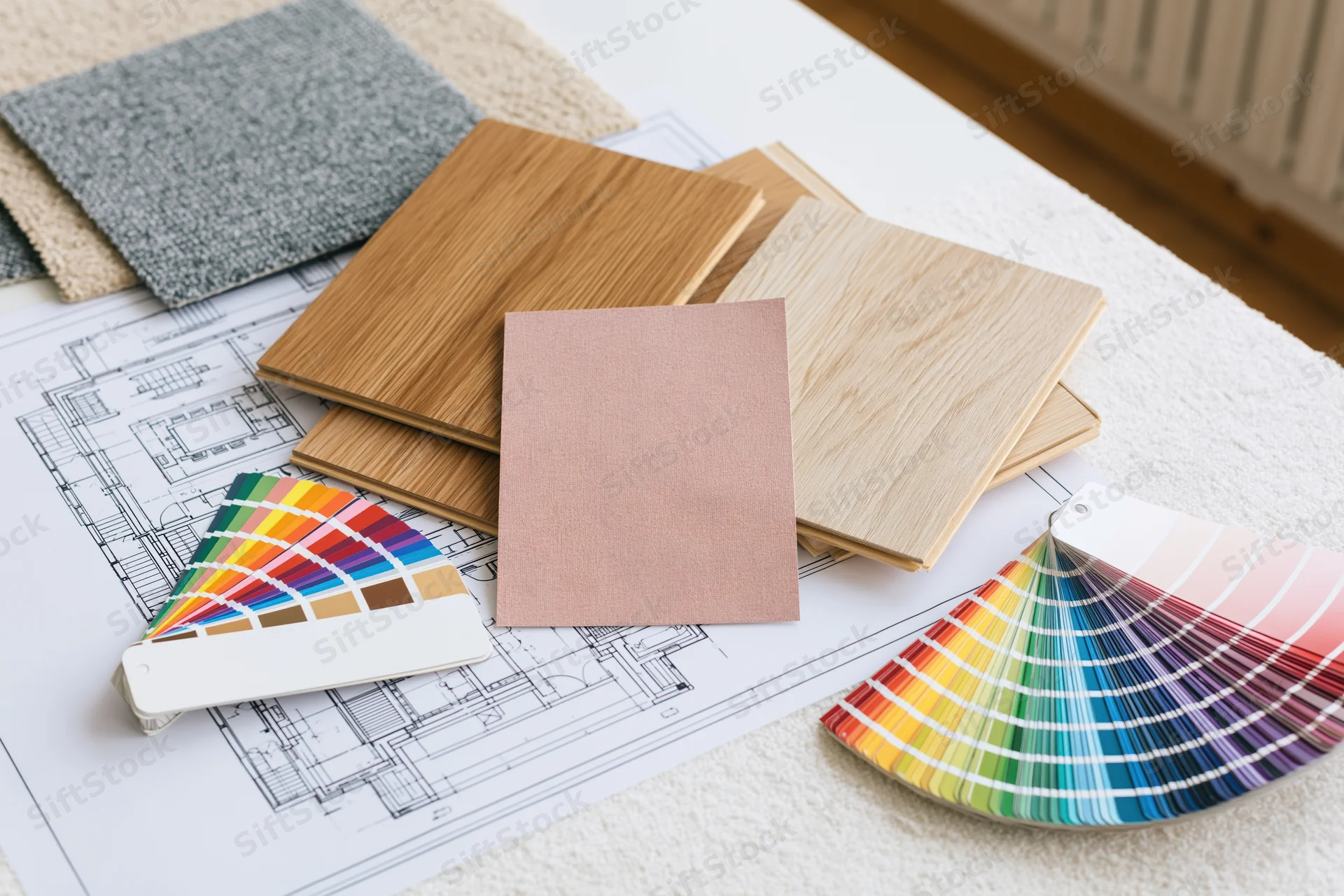Architectural floor plan with material and color samples arranged on a table for interior design planning