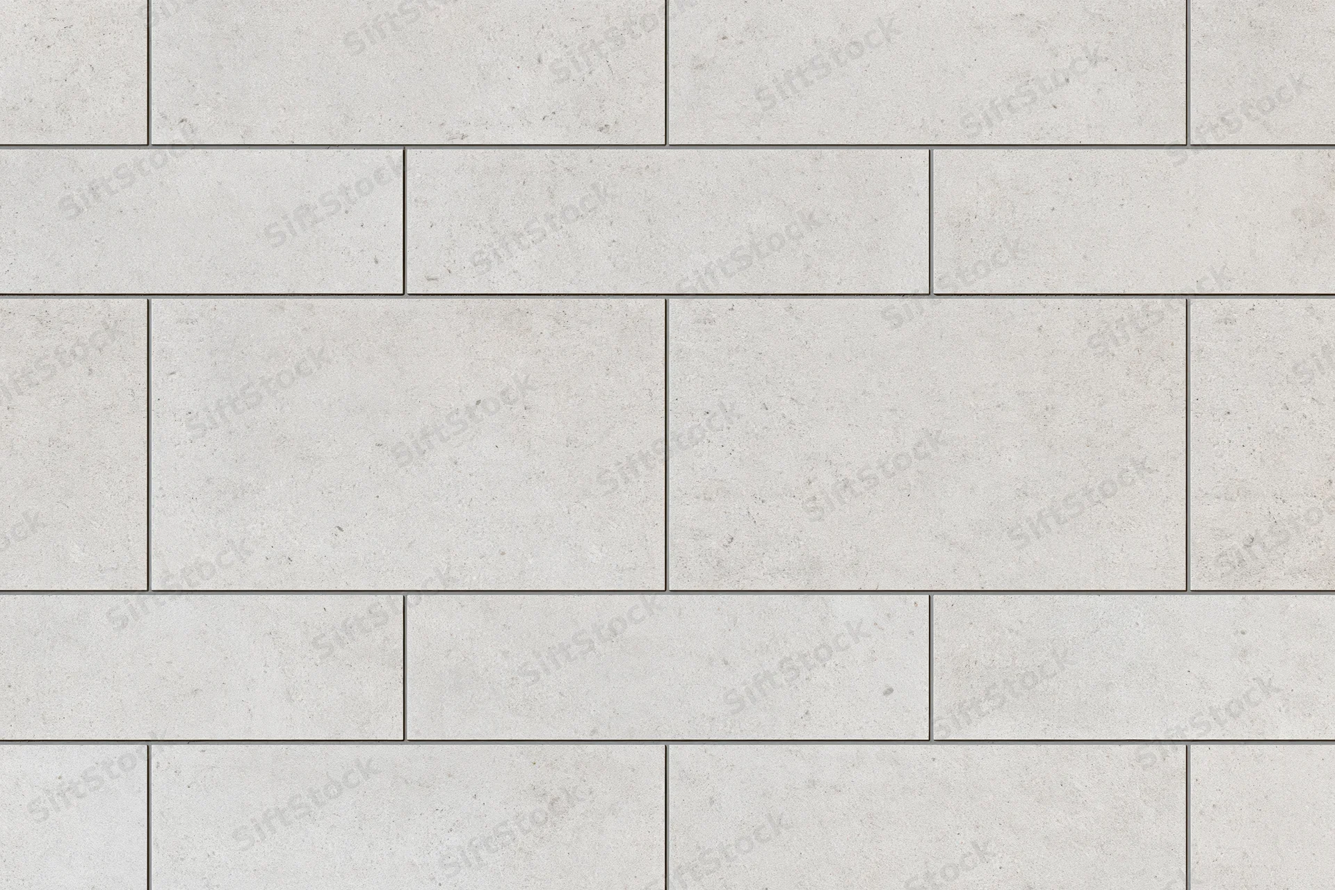 Large-format concrete-look ceramic tiles arranged in a staggered grid pattern for interior flooring or wall cladding