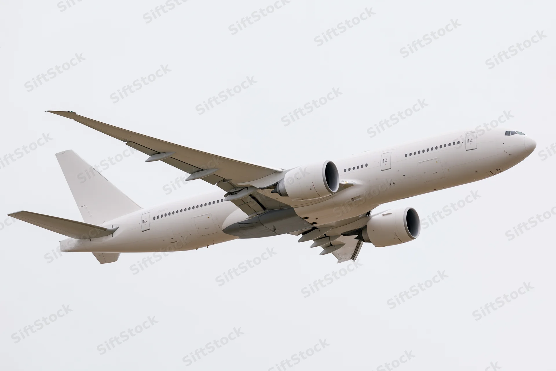 White wide-body commercial passenger jet in level flight against overcast sky