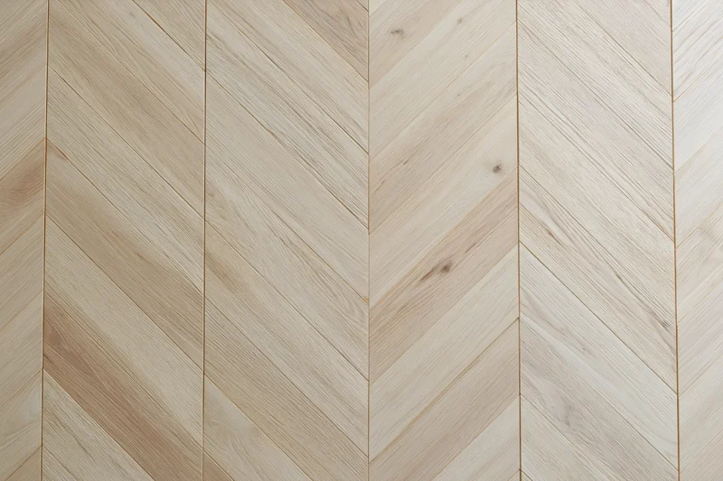Light oak parquet flooring arranged in a chevron pattern for interior design