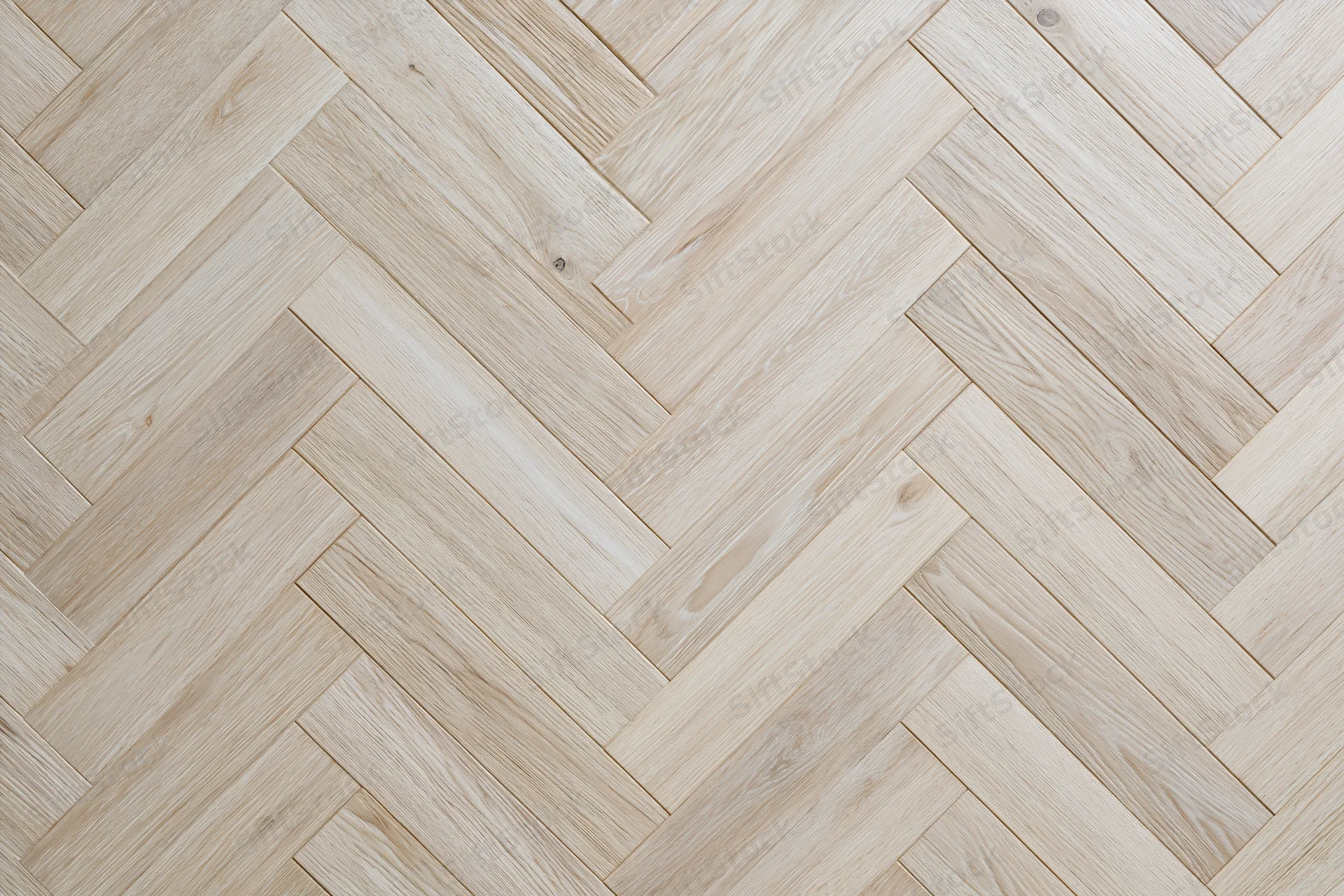 Light oak parquet flooring arranged in a herringbone pattern for interior use