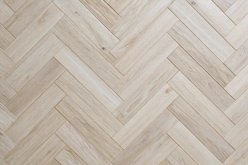Light oak parquet flooring arranged in a herringbone pattern for interior use