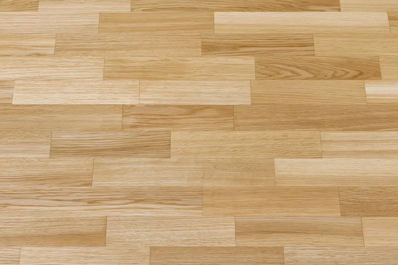 Light oak hardwood parquet floor filling the frame with natural wood grain pattern