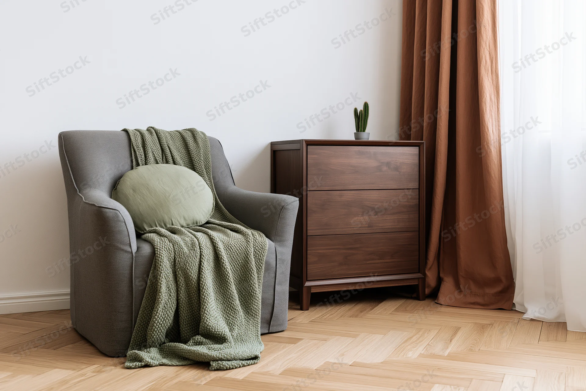 Gray armchair with green blanket and cushion beside walnut dresser in bedroom corner near window with brown curtains