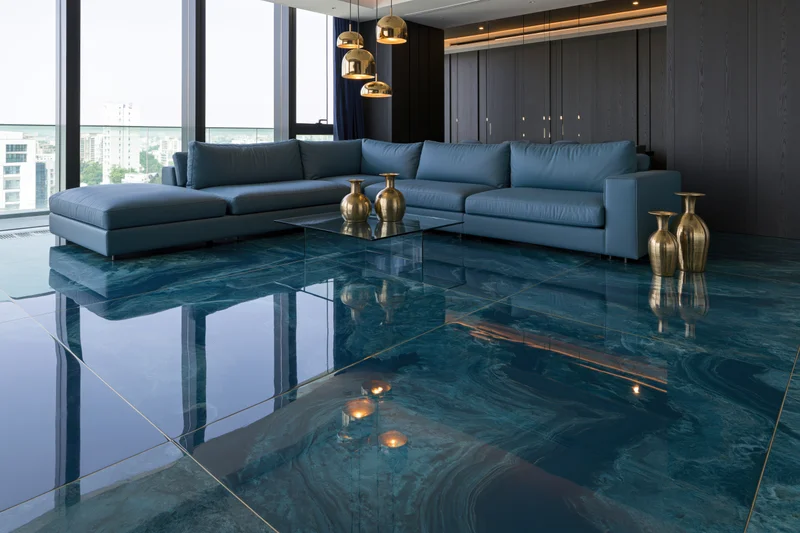 Modern luxury living room with glossy epoxy resin floor and blue sectional sofa near large windows overlooking city