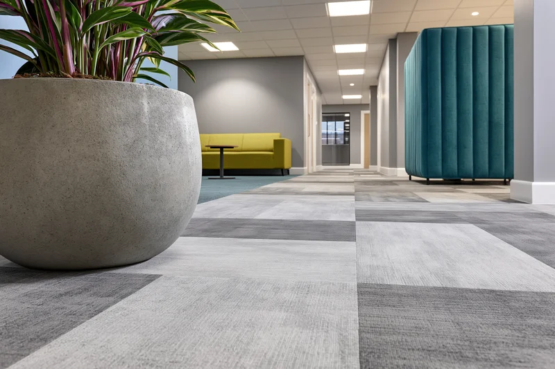 Modern office corridor with patterned carpet tiles and seating areas