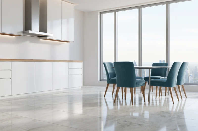 Modern open-plan kitchen and dining area with marble flooring and city view through large windows