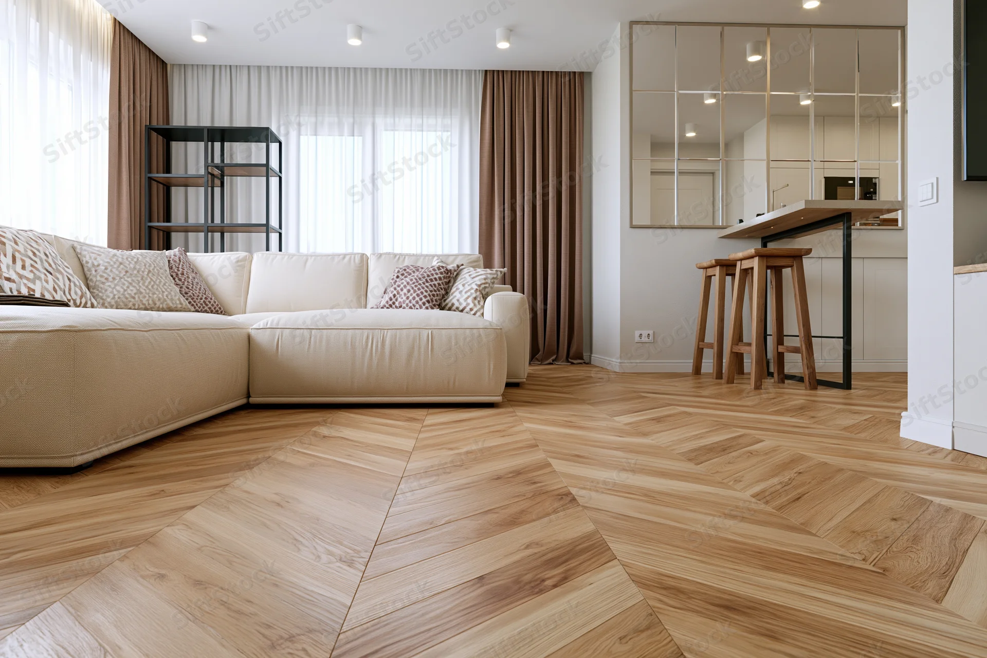 Modern open-plan living room with beige sectional sofa and herringbone wood flooring viewed from low angle