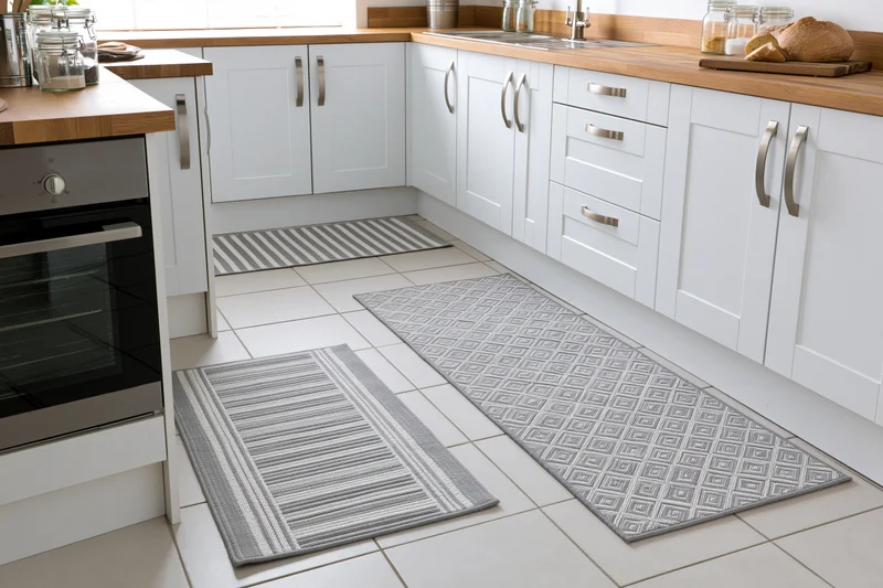 Modern white kitchen with wooden countertops and patterned rugs on tiled floor