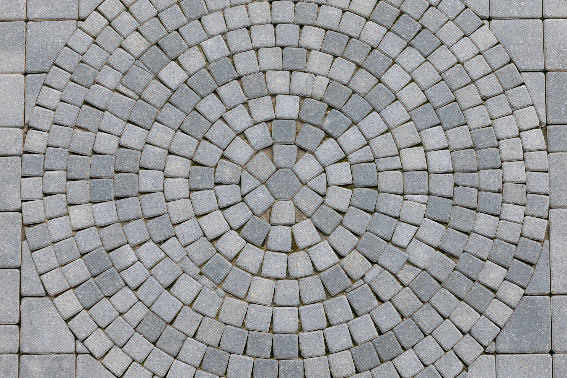 Circular grey concrete cobblestone pattern on outdoor patio flooring