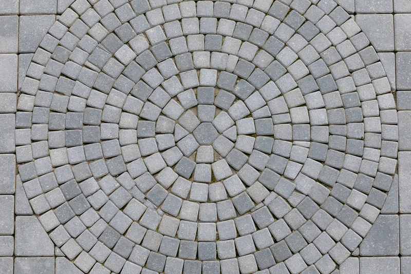 Circular grey concrete cobblestone pattern on outdoor patio flooring