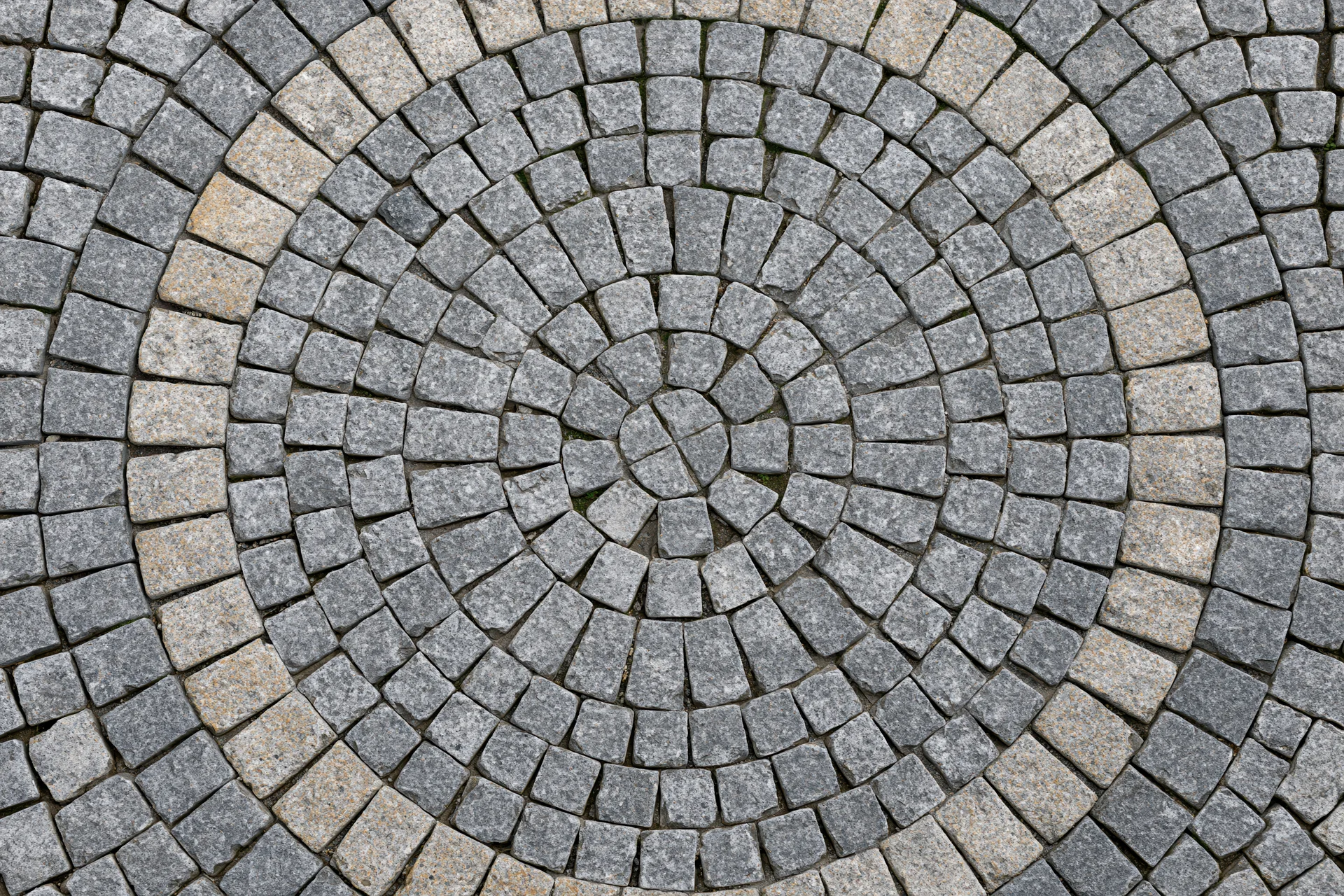 Circular cobblestone patio arranged in concentric rings on outdoor ground surface