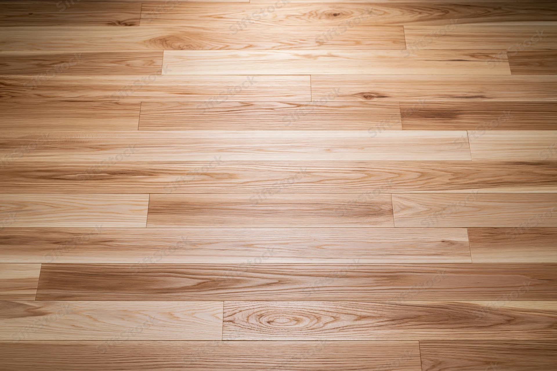 Overhead view of light oak hardwood floor planks arranged in parallel rows across a smooth interior surface