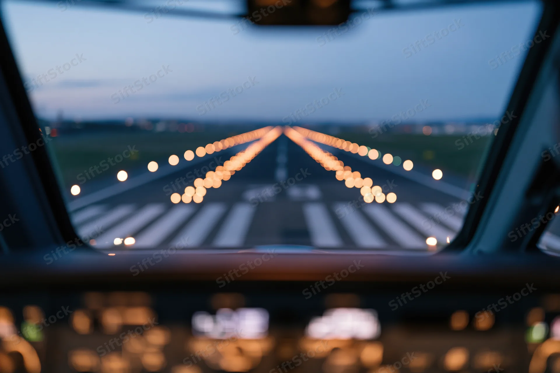 View from aircraft cockpit during runway approach at dusk
