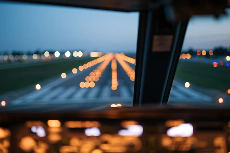 View from aircraft cockpit during runway approach at twilight