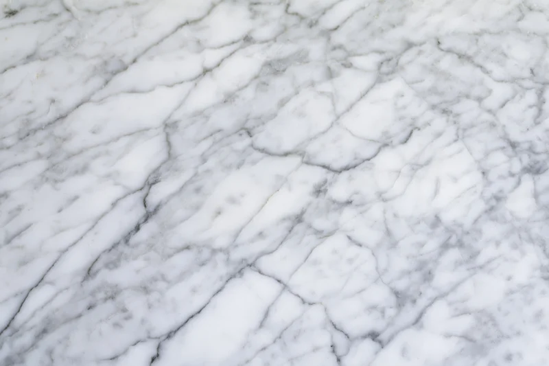 White marble surface with gray veining filling the frame in flat-lay view