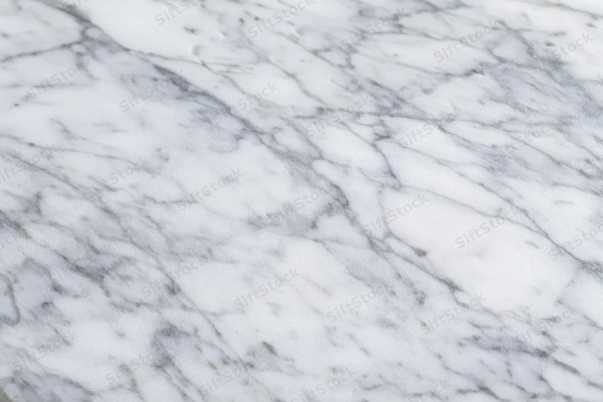 White marble surface with gray veining filling the frame as a textured background