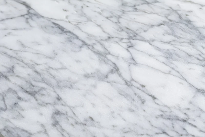 White marble surface with gray veining filling the frame as a textured background