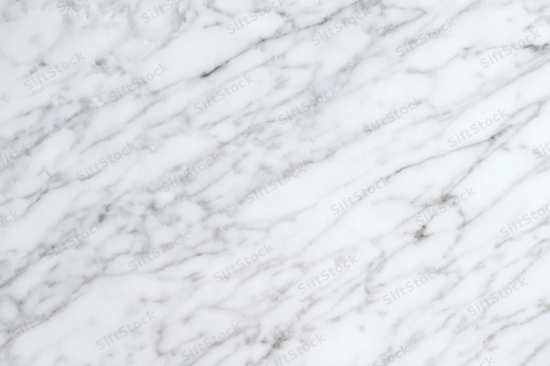 White marble surface with gray veining filling the frame as a seamless background