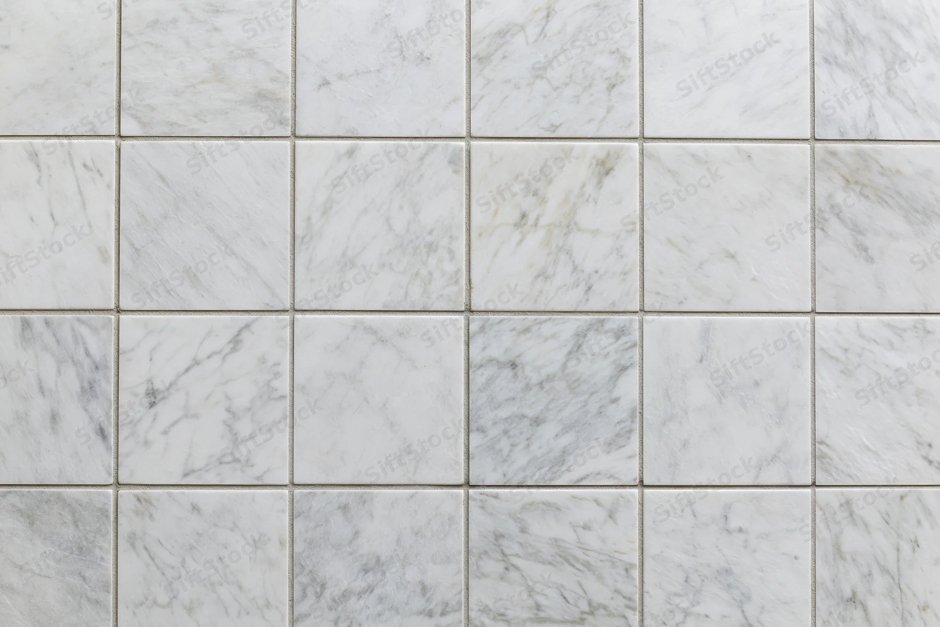 White marble tiles arranged in a grid pattern covering the wall surface