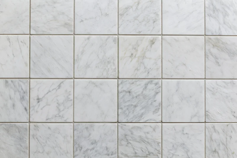 White marble tiles arranged in a grid pattern covering the wall surface