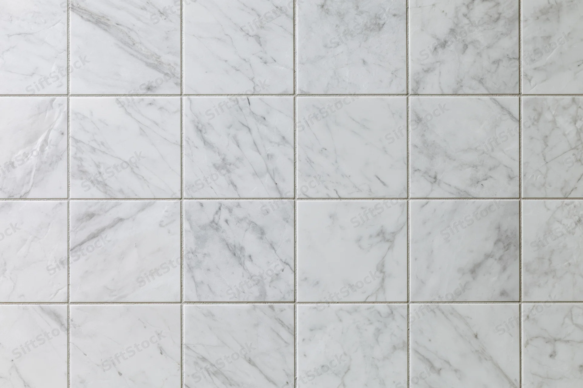 White marble tile wall arranged in a grid pattern filling the frame