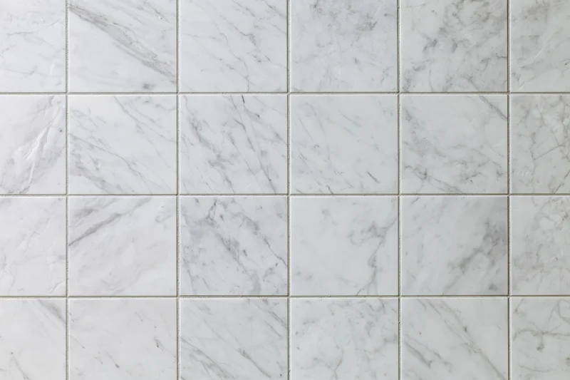 White marble tile wall arranged in a grid pattern filling the frame