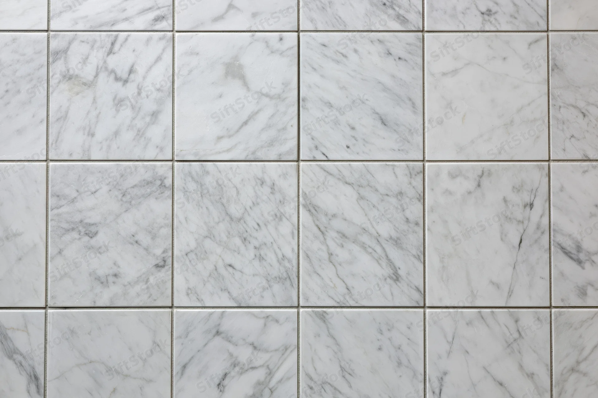 White marble tile wall arranged in a grid pattern filling the frame