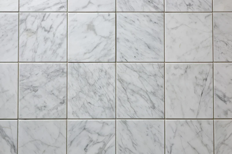 White marble tile wall arranged in a grid pattern filling the frame