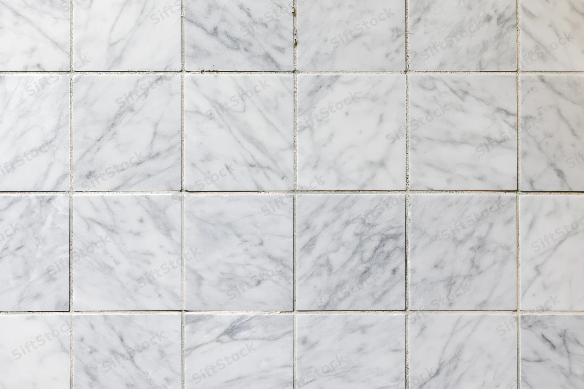 White marble tile wall arranged in grid pattern filling the frame