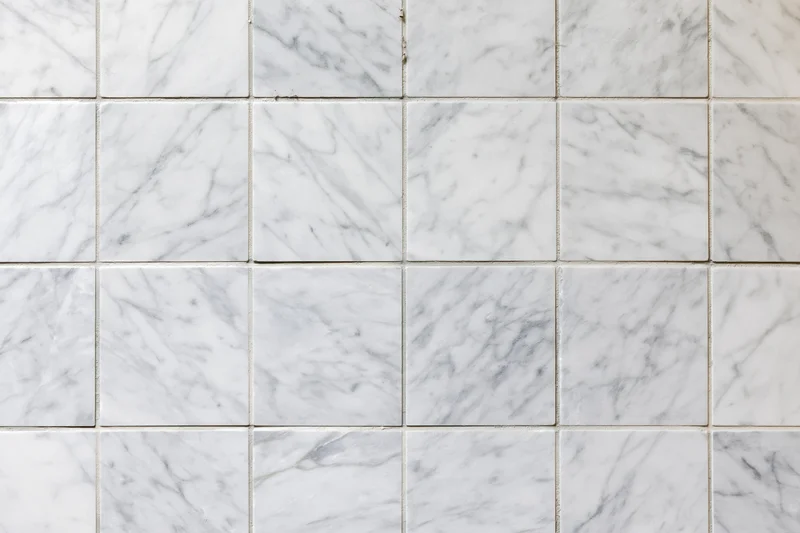 White marble tile wall arranged in grid pattern filling the frame