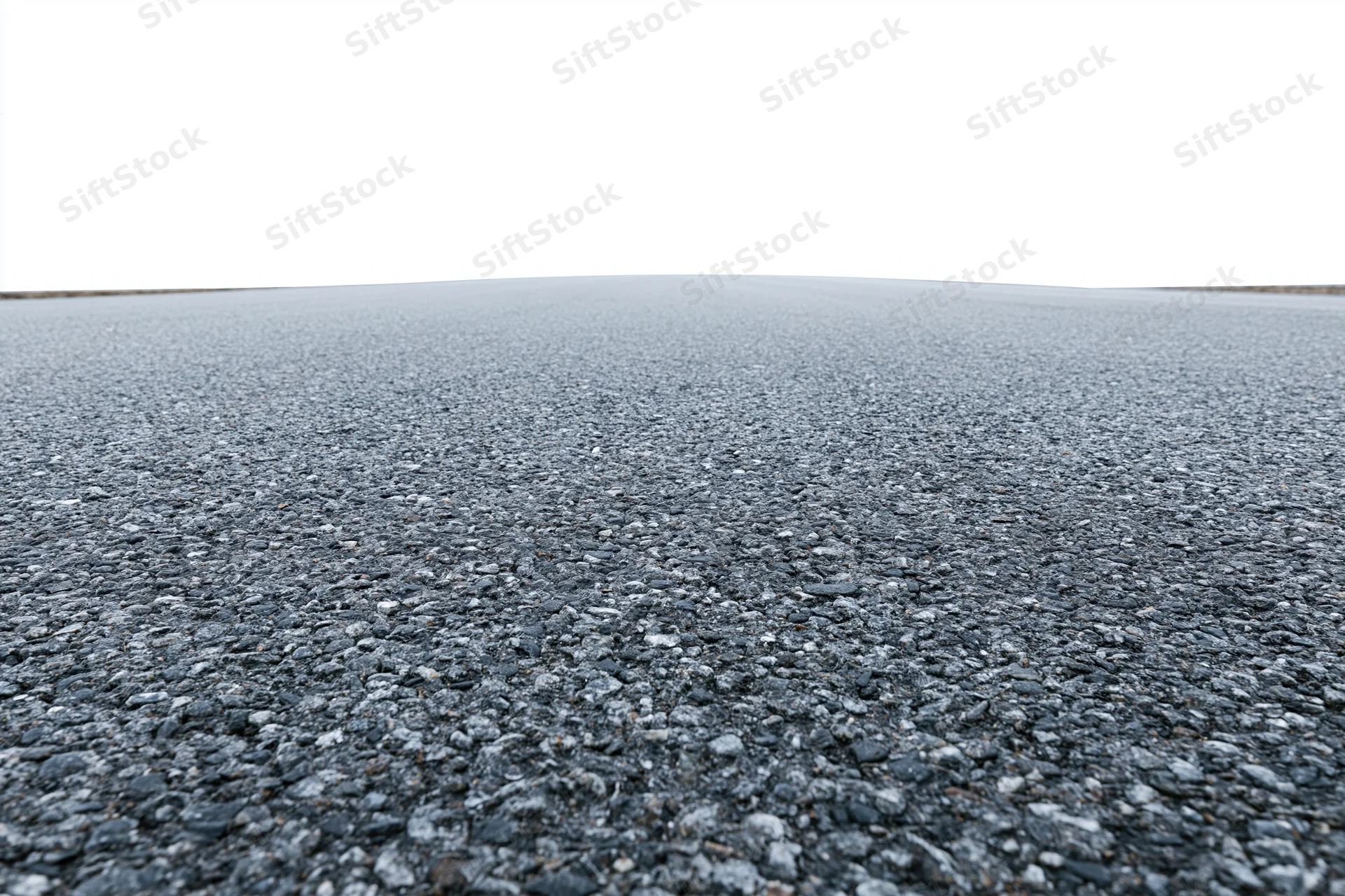 Flat empty asphalt surface stretching to the horizon under overcast sky