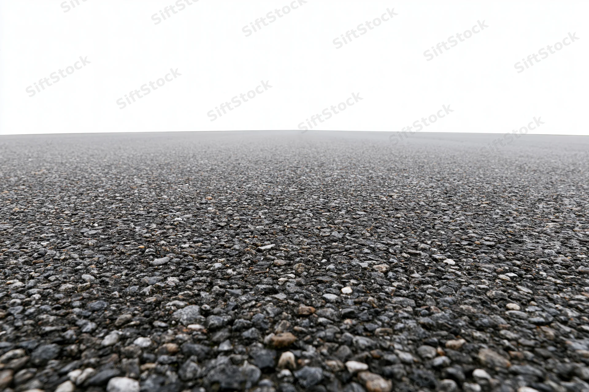 Wide low-angle view of flat empty asphalt surface stretching to horizon