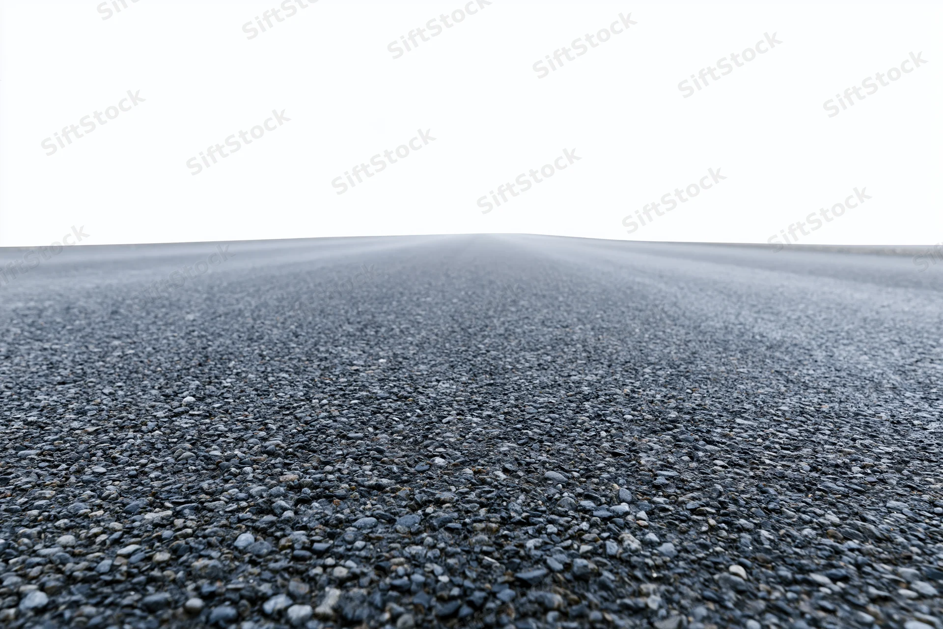 Wide low-angle view of flat empty asphalt road stretching toward horizon