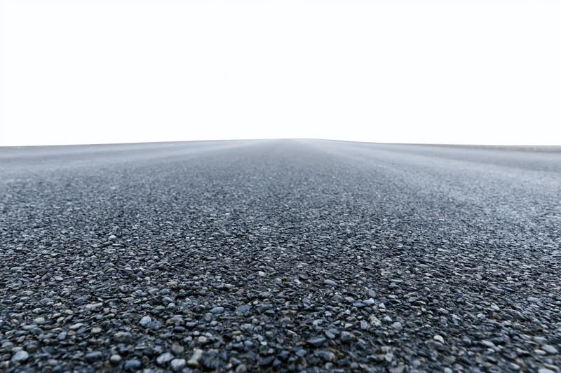 Wide low-angle view of flat empty asphalt road stretching toward horizon