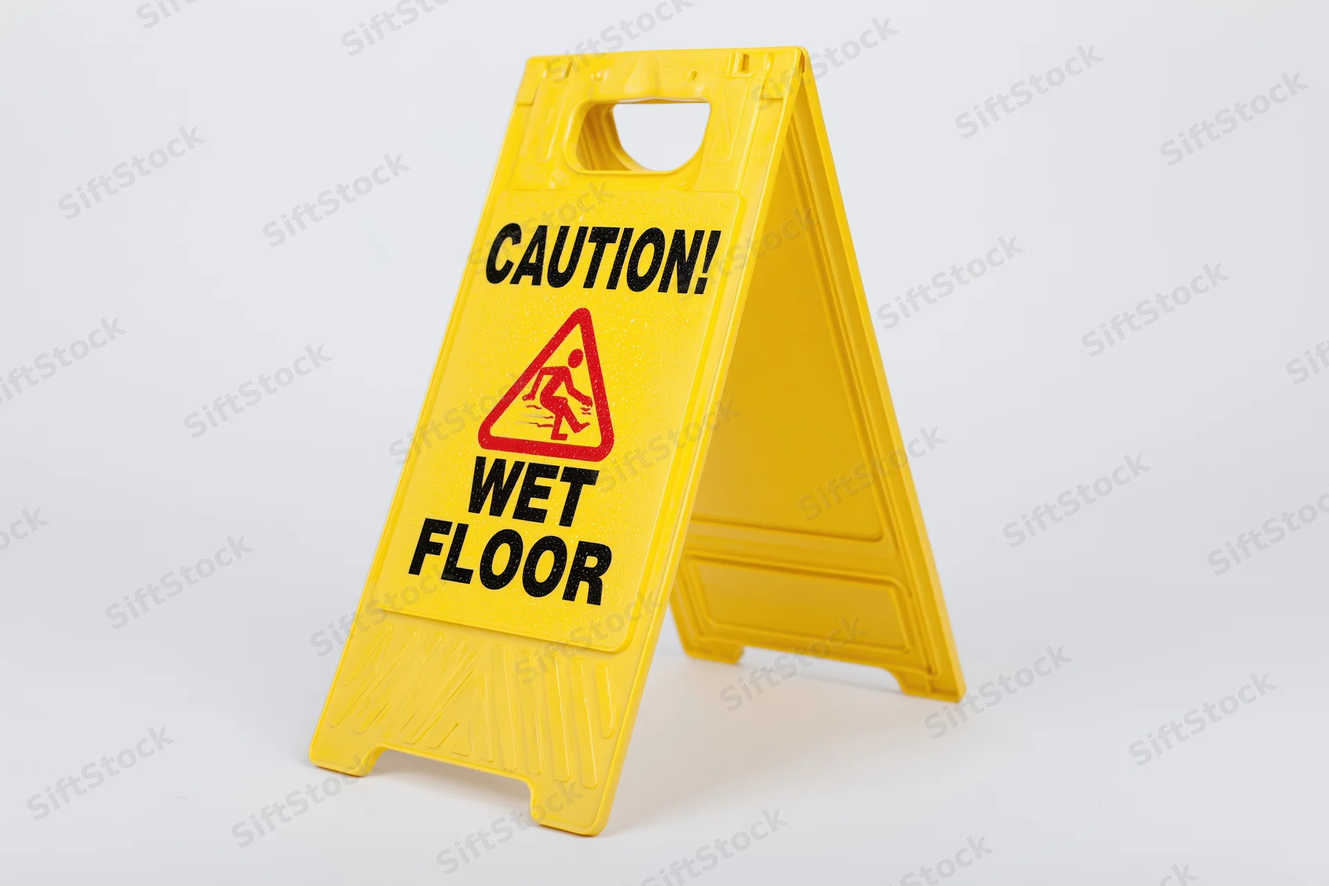 Yellow plastic a-frame caution wet floor sign standing on white background