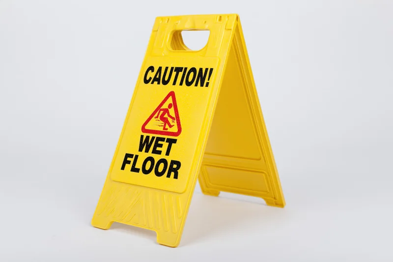 Yellow plastic a-frame caution wet floor sign standing on white background