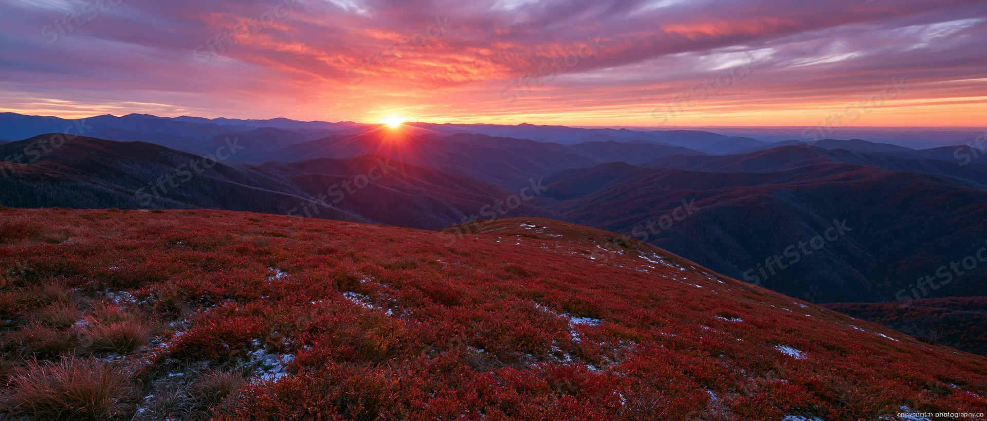 Autumn mountain ridge at sunset with forested valleys and colorful sky