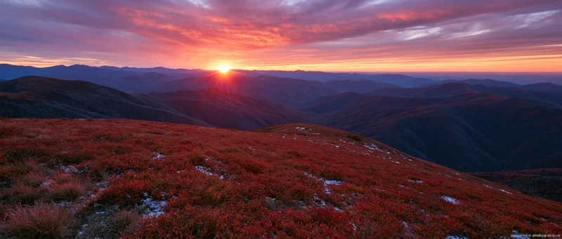 Autumn mountain ridge at sunset with forested valleys and colorful sky