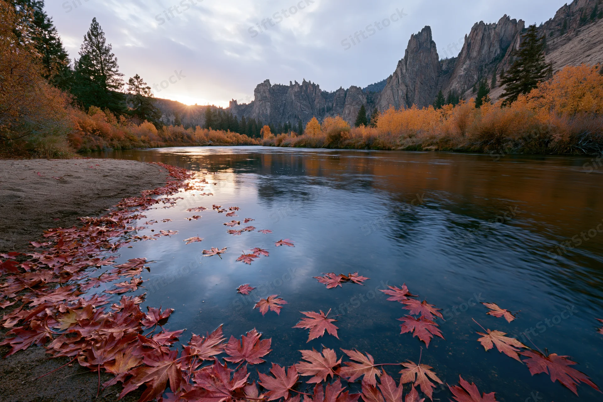 Calm river reflecting sunset light among autumn trees and mountains