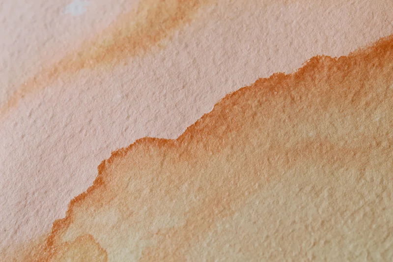 Watercolor paint wash blending across textured paper surface