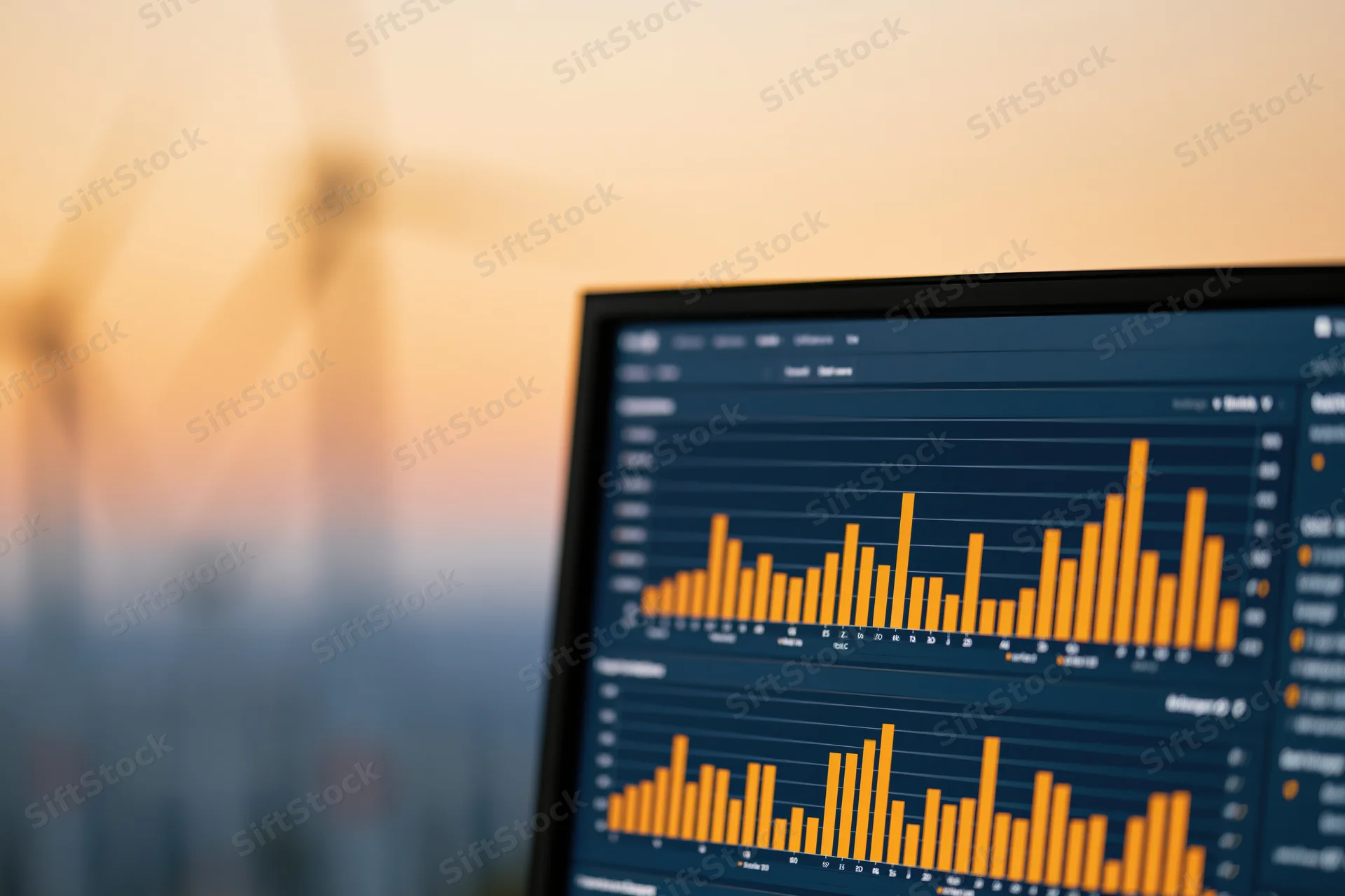 Dark digital dashboard showing energy analytics with bar graphs and wind turbines in blurred background at sunset