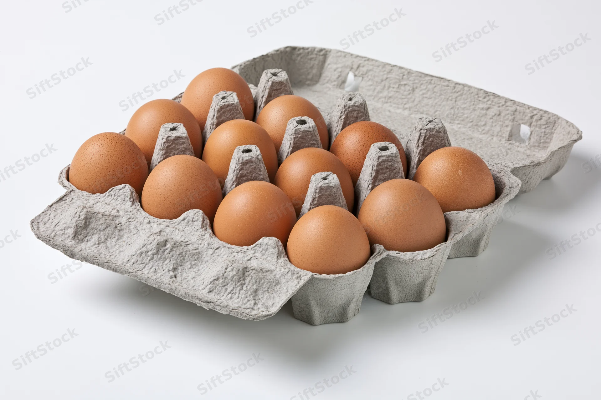 A dozen brown chicken eggs arranged in an open gray cardboard carton on a white surface