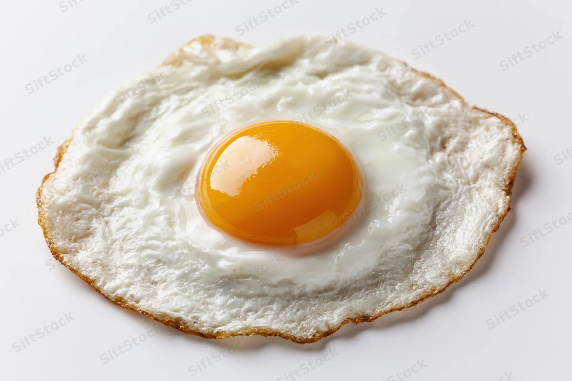 Single fried egg sunny side up resting flat on white surface