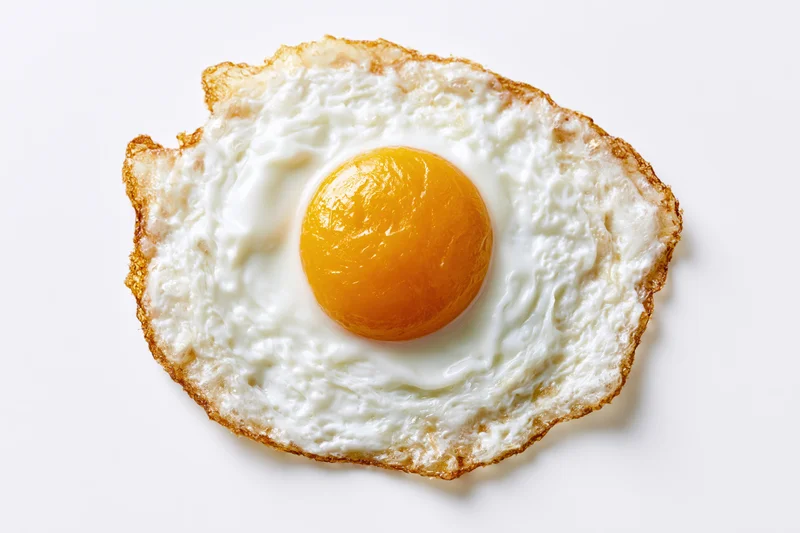 Single fried egg sunny side up on white background
