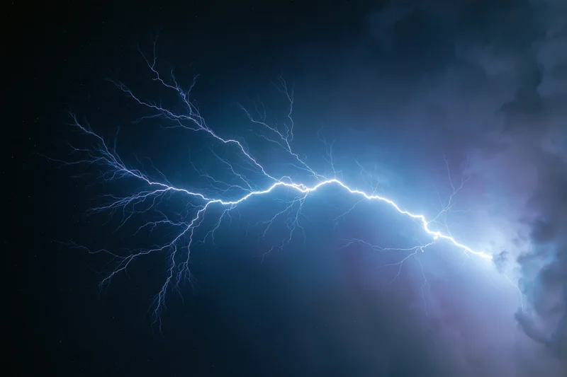 Jagged lightning bolt stretching horizontally across dark stormy sky at night