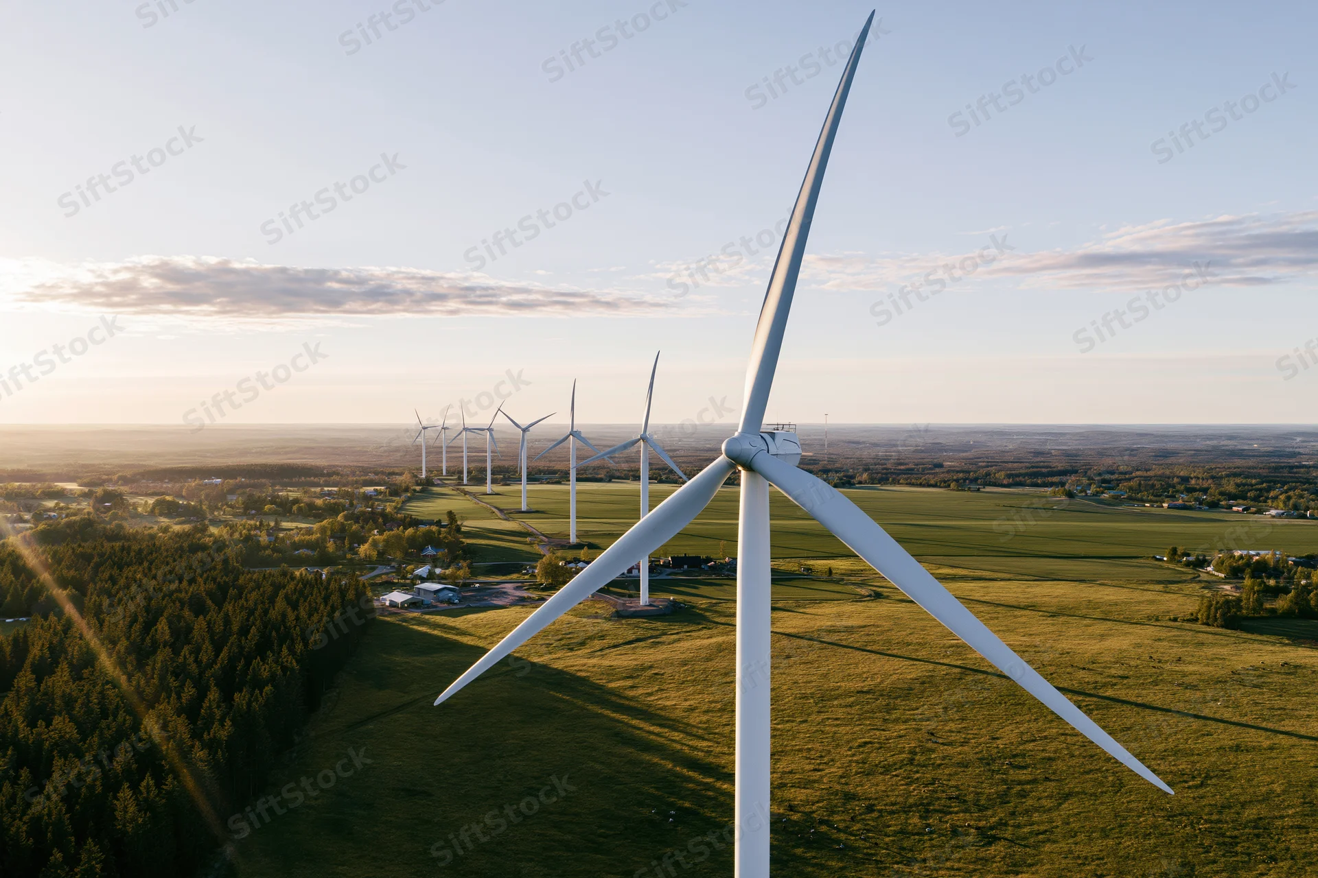 Aerial view of wind turbines in a rural field at sunset