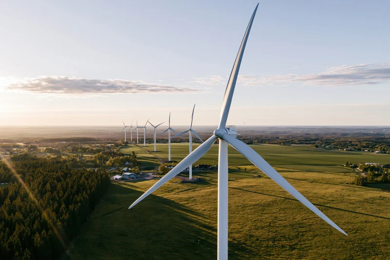 Aerial view of wind turbines in a rural field at sunset