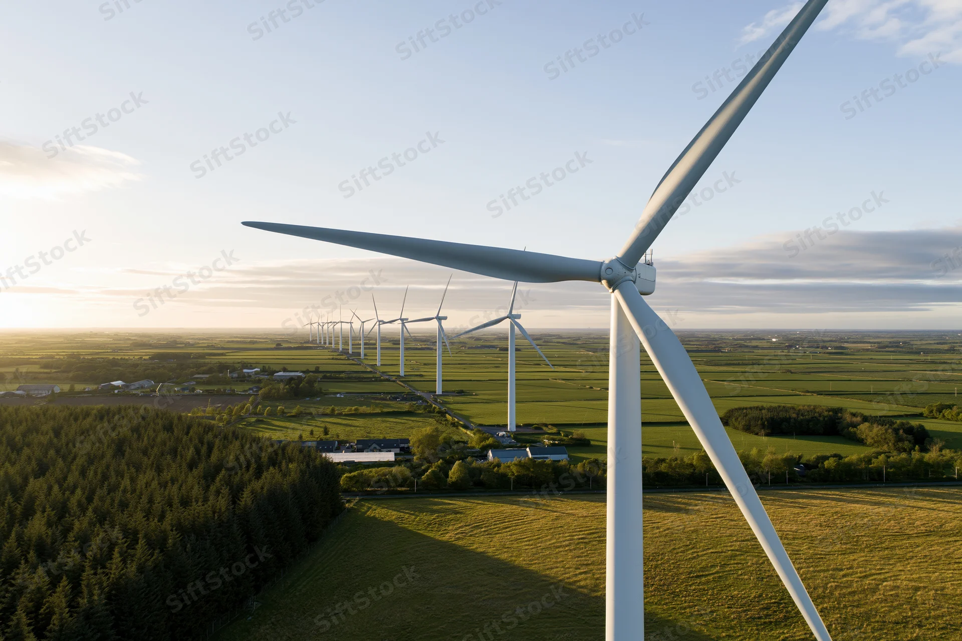 Aerial view of wind turbines in a rural field at sunset